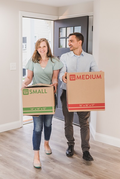 un couple qui porte deux cartons